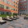 a courtyard with benches and plants in front of a building