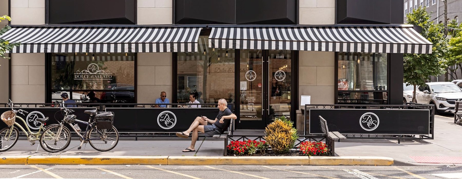 a person sitting on a bench in front of a store