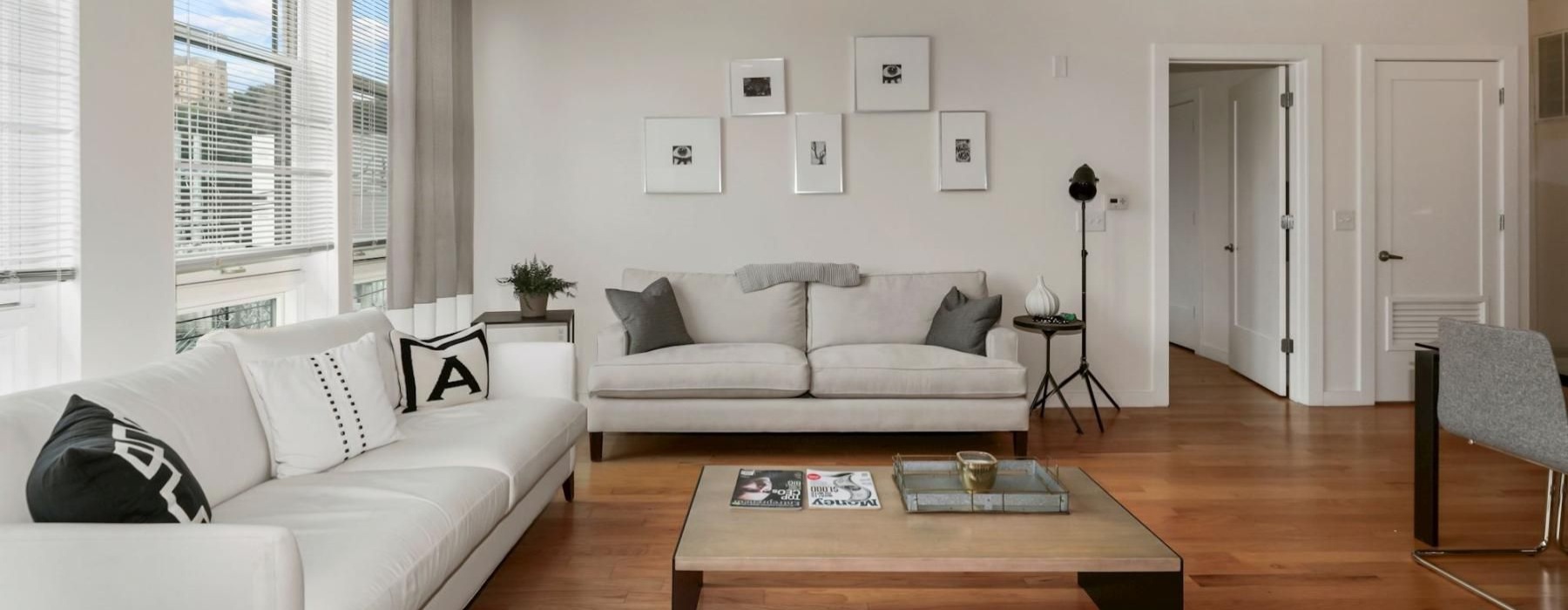 a living room with a large window and couches