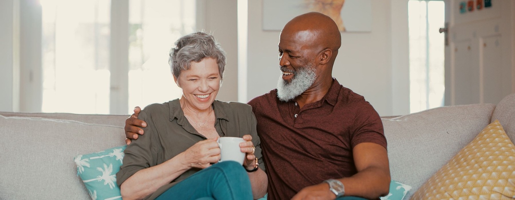 smiling, older couple, sit together on a couch